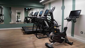 Une salle de sport équipée de tapis de course et d’un appareil elliptique.