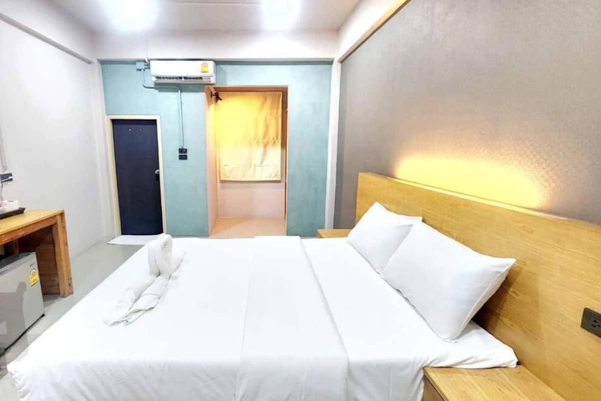 Une chambre d’hôtel équipée d’un lit, d’une table de chevet et d’un appareil de climatisation.