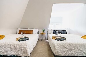 A room with two beds, a small table with a plant, and a window with a view. - Short North & Downtown & OSU | Near High Street | Free Parking | 5,800+ Reviews (Columbus)