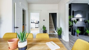 A dining area with a wooden table, yellow chairs, and potted plants. - Short North & Downtown & OSU | Near High Street | Free Parking | 5,800+ Reviews (Columbus)