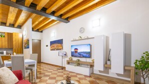 A living room with a checkered floor, a red sofa, a TV, and a wooden ceiling. - You & Me Corporation Home Verona Centro (Verona)