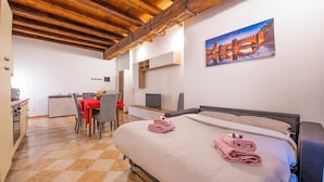 A hotel room with a bed, a desk, a chair, a TV, and a painting on the wall. - You & Me Corporation Home Verona Centro (Verona)