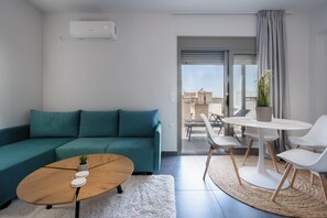 Deluxe Penthouse, City View | Living area | 43-inch TV with cable channels