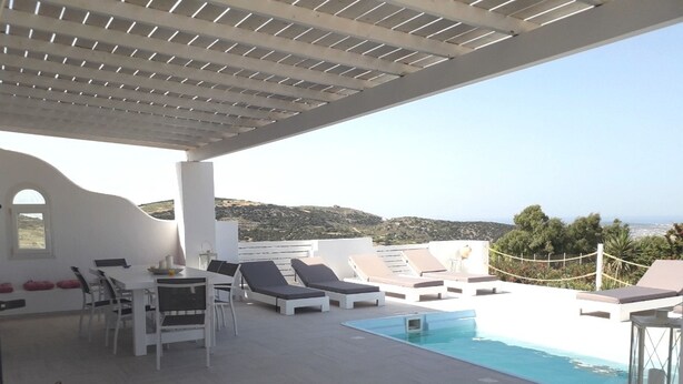 A rooftop pool area with lounge chairs and a dining table, overlooking a scenic landscape. - Dreamcatcher Sea View Mini Pool Paros (Paros)