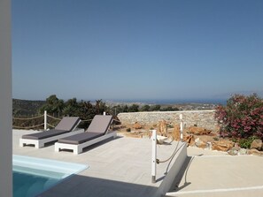 A poolside area with lounge chairs and a view of the landscape. - Dreamcatcher Sea View Mini Pool Paros (Paros)