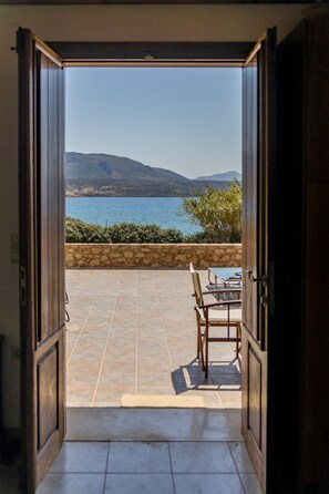 An open door leading to a patio with a view of the sea and mountains. - Sea Front Stone Villa Near Monemvasia (Monemvasia)