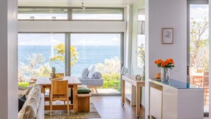 Een moderne keuken met uitzicht op zee, houten meubels en een eethoek.