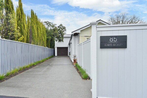 A residential driveway leading to a garage with a house number sign.