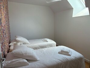 2 habitaciones, escritorio y tabla de planchar con plancha