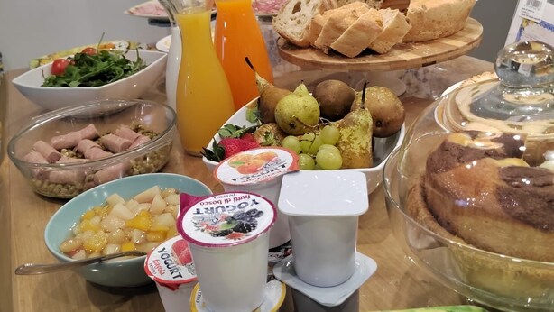 Un bufé de desayuno con diversas opciones de comida, como pan, frutas y yogur.