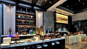 A buffet setup with various dishes, utensils, and decorative items on a marble counter. - Meshee Sezen Hotel Suzhou (Suzhou)
