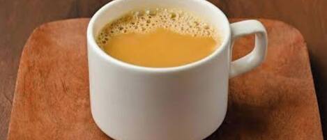 A white mug with a handle on a wooden surface.