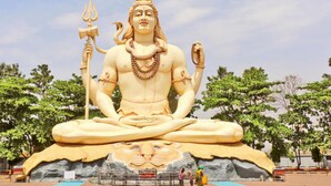 A large statue of a deity seated in a meditative pose with a lion's face at the base. - AYUSHMAAN- Premium (Jabalpur)