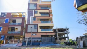 A multi-story residential building with balconies, a construction crane, and a partially built structure. - Sanskriti Homestay (Tirupati)