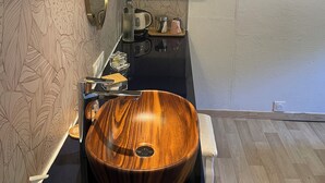 A modern bathroom with a wooden vanity, a large mirror, and a built-in sink. - Péniche Le Pescalune (Arles)