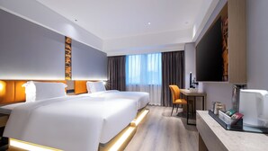 A hotel room with two beds, a desk, a chair, and a TV. - Dengting Hotel (Haikou)