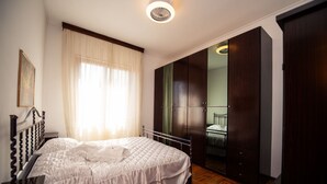 A bedroom with a bed, a wardrobe, and a mirror.