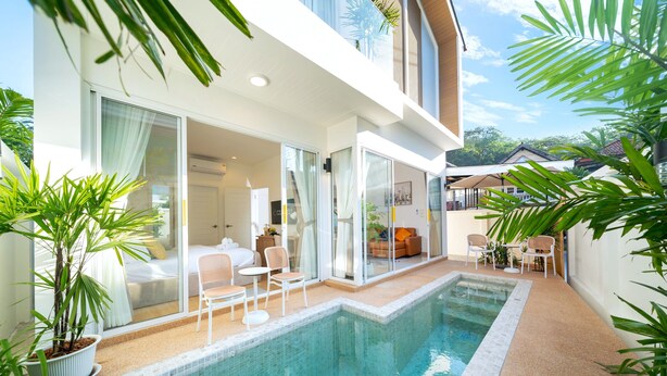 A modern hotel with a swimming pool, outdoor seating, and lush greenery. - Goldena Twin Kamala (Kamala)