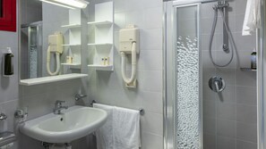 A modern bathroom with a white sink, a glass shower enclosure, and a mirror with built-in soap dispensers. - Sunny family oasis with water games and beach (Bibione)