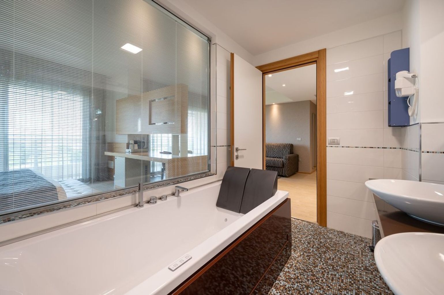Une salle de bain moderne dotée d’une grande baignoire, d’un lavabo séparé et d’une cabine de douche en verre.
