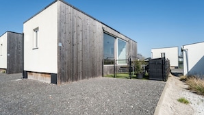 A modern building with a large window and a wooden facade. - Beautiful apartment in villa for 4 guests with WIFI, A/C, TV, terrace and pets allowed (Bruges)