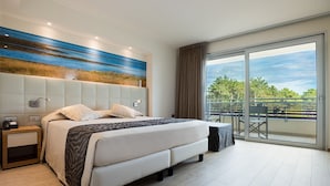 Ein modernes Schlafzimmer mit einem großen Bett, einem Nachttisch, einer Wandlampe und Blick ins Freie durch eine Glasschiebetür.