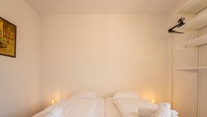 Habitación de hotel con dos camas, ropa de cama blanca y toallas.
