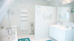 A bathroom with a bathtub, a sink, and a shower.