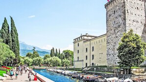 A historic building with a tower, a canal with boats, and a park with people walking. - Beautiful apartment for 4 guests with WIFI, A/C, TV, patio and panoramic view (Dro)