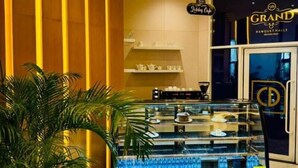 Un présentoir à desserts dans le hall d’un hôtel, avec une plante en pot à proximité.