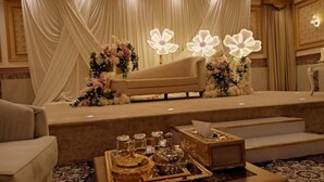 Une scène avec un canapé, des compositions florales et un plateau avec de la verrerie.