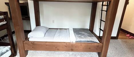 Una cama litera con una cama inferior y un colchón en el suelo.