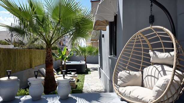 A patio with a hanging chair, outdoor furniture, and a hot tub. - El Dorado Corner (Chania)