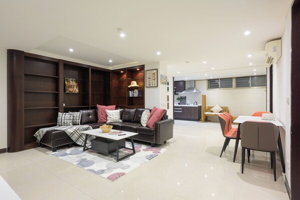 Una sala de estar moderna con un sofá, una mesa de centro y un comedor con sillas.