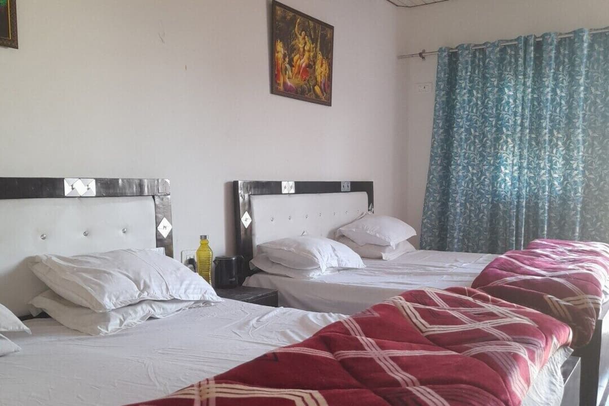 A hotel room with two beds, a painting on the wall, and a window with curtains.