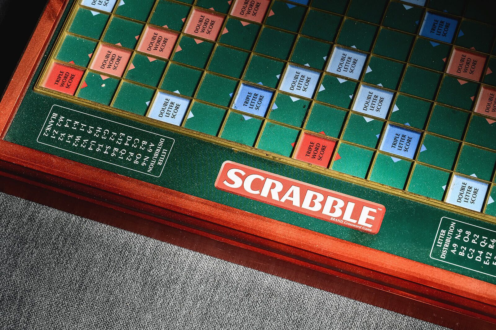 Un juego de Scrabble con tablero verde y borde rojo.