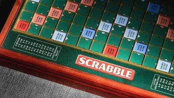 Un juego de Scrabble con tablero verde y borde rojo.