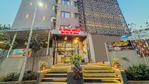 A hotel entrance with a sign for 'BY SPREE HOTELS' and a modern building with a patterned facade. - Zip By Spree Hotels Chinchwad (Pimpri - Chinchwad)
