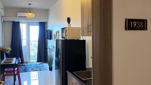 Eine moderne Küche mit einem schwarzen Kühlschrank, Holzschränken und einem Essbereich mit Tisch und Stühlen.