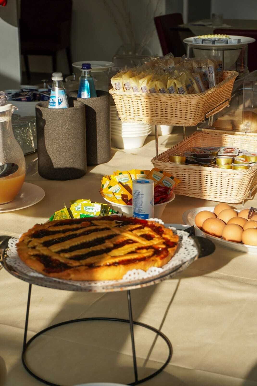 A breakfast buffet with a variety of food items including a pie, eggs, and beverages.