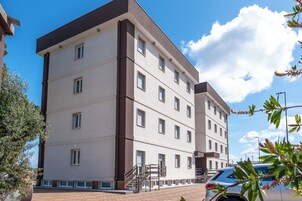 Un edificio de varios pisos con techo plano y una escalera central.