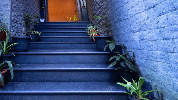 A staircase leading to a wooden door with a sign reading "Sanderling Residency." - SUMITEL SANDERLING (Darjeeling)