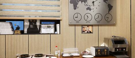 A breakfast area with a world map, clocks, a self-made fried eggs sign, a toaster, and a coffee machine.