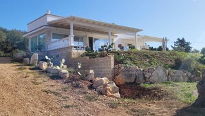 A modern two-story house with a balcony, surrounded by rocks and cacti. - Complesso Villa Vanissia (Castrignano del Capo)