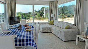 A modern living room with a checkered table, a sofa, and a TV. - Complesso Villa Vanissia (Castrignano del Capo)