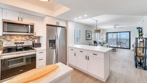 A modern kitchen with white cabinetry, stainless steel appliances, and a central island. - UPDATED 2B/2B BEACHFRONT CONDO SEASIDE 301 (Fort Myers Beach)