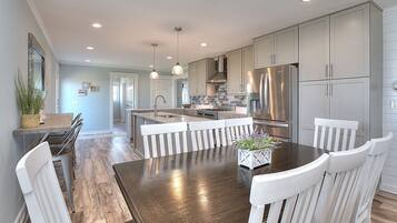 A modern kitchen with a central island, stainless steel appliances, and white cabinetry.