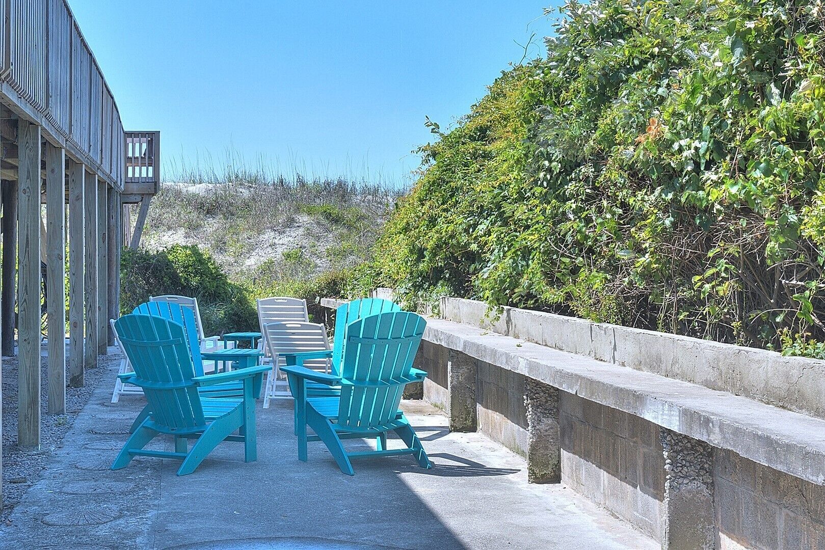 A patio with outdoor seating and a view of the beach.