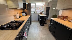 Una cocina moderna con estufa a gas, gabinetes negros y encimera de madera.