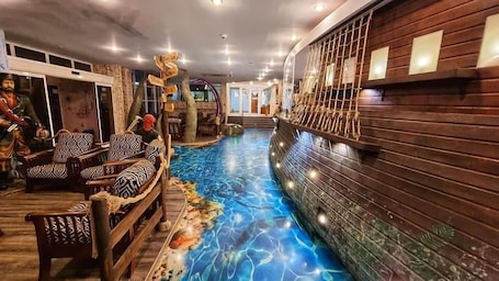 A spa area with a pool, wooden seating, and a decorative wall.